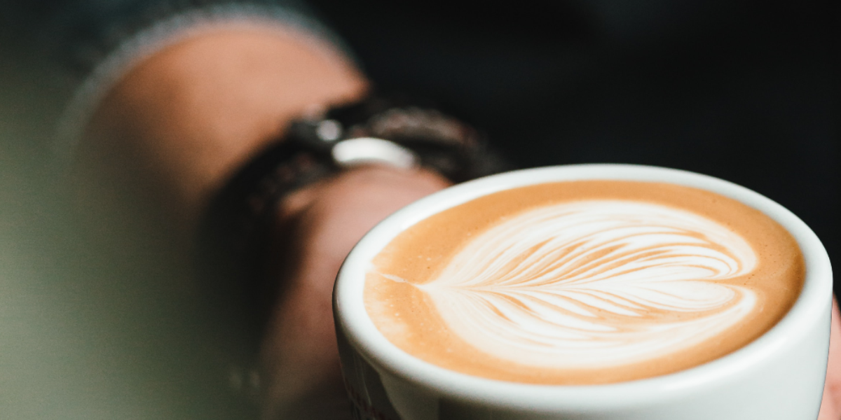 man holding a cup of coffee on a black background