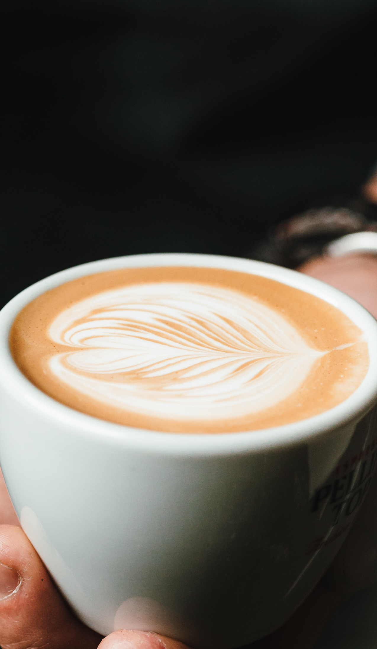 man holding a cup of coffee on a black background